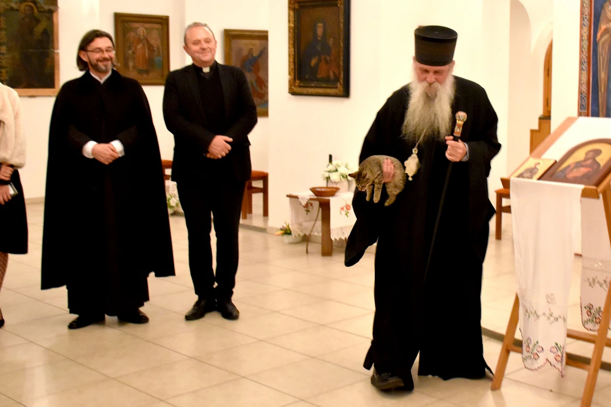 Mače u naručju episkopa Ćulibrka na otovrenju izložbe u hramu sv. Gerogija u Požegi